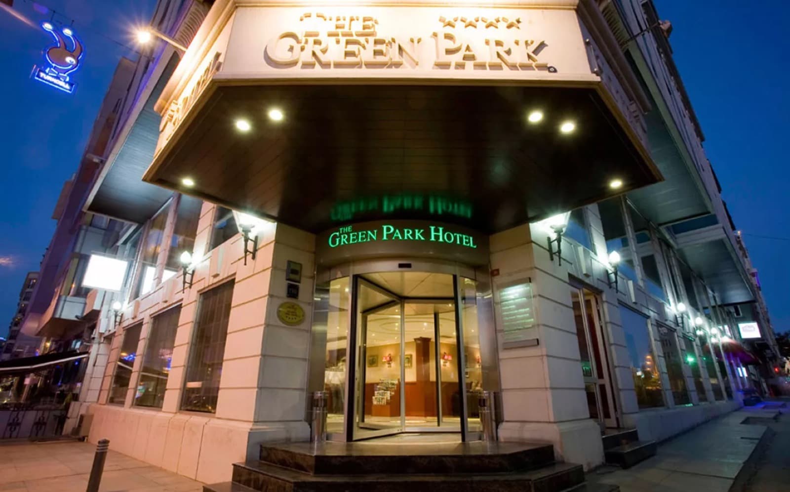 Corner entrance of The Green Park Hotel Taksim lit at dusk in Beyoglu, Istanbul